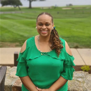 A person smiling and wearing a green shirt